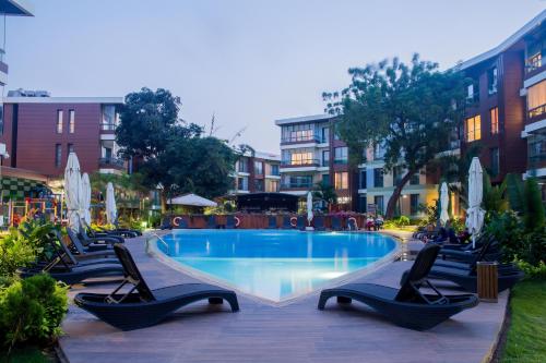 阿克拉的住宿－Accra Fine Suites - The Pearl In City，一个带躺椅和椅子的游泳池