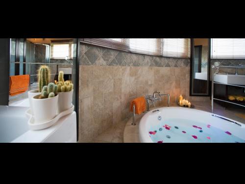 a bathroom with a large tub with cactuses and a fireplace at Villa Privilege Classic & Exclusive in Gouvia