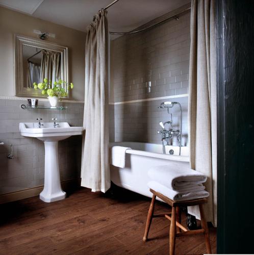 a bathroom with a sink and a bath tub and a sink at The Crown And Thistle, Abingdon in Abingdon