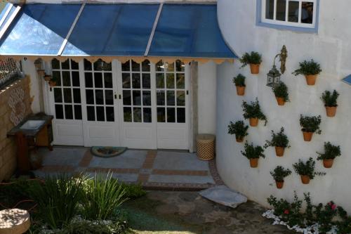 a house with a blue awning and potted plants at POUSADA CASARÃO NORONHA KAUAGE in Cristina