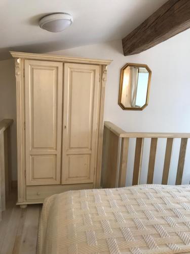 a bedroom with a wooden cabinet and a bed at Couvent des Carmes in Narbonne