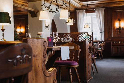 a restaurant with a wooden table with chairs and a bar at Gutshof Sagmühle in Bad Griesbach