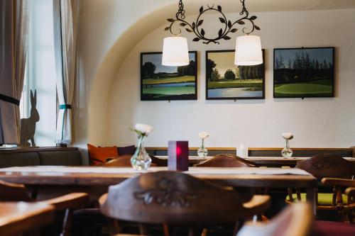 a restaurant with tables and chairs and pictures on the wall at Gutshof Sagmühle in Bad Griesbach