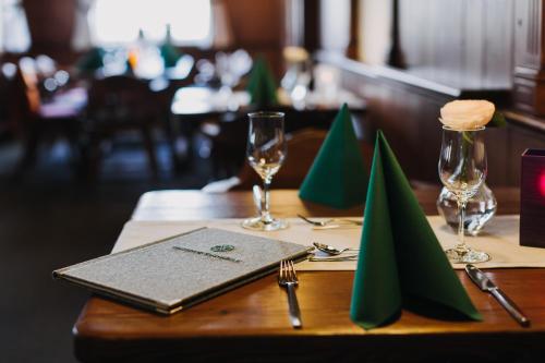 a wooden table with two glasses and a napkin at Gutshof Sagmühle in Bad Griesbach