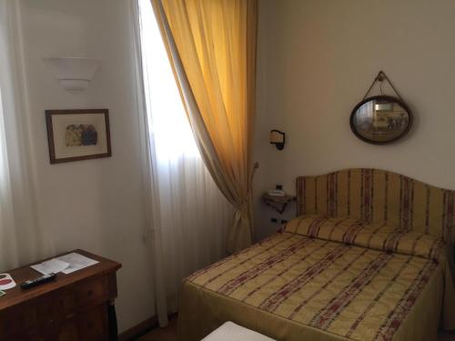 a small bedroom with a bed and a window at Al Teatro in Livorno