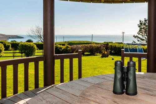 einen Tisch auf einer Veranda mit Meerblick in der Unterkunft Ardkilly Ridge, Kinsale Town,Sleeps 8 in Kinsale