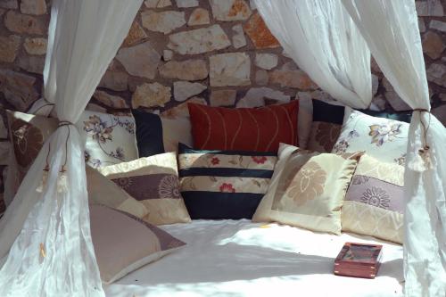 a bed with curtains and pillows in a room at Opera House Paxos in Gaios