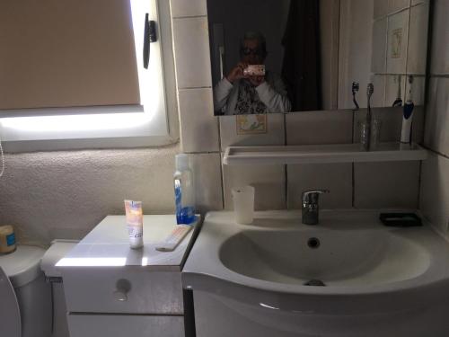 a person taking a picture of a bathroom sink at L'Eden in Ansouis