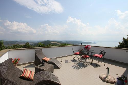 a balcony with chairs and a table with a view at Villa La Moraiola in Passignano sul Trasimeno
