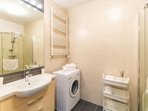 a bathroom with a washing machine and a sink at Apartamenty Polanki - visitopl in Kołobrzeg