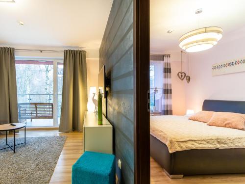 1 dormitorio con cama y taburete azul en Apartamenty Polanki - visitopl, en Kołobrzeg