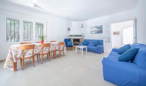 ein Wohnzimmer mit einem blauen Sofa, einem Tisch und Stühlen in der Unterkunft El Far De La Galera in Torredembarra