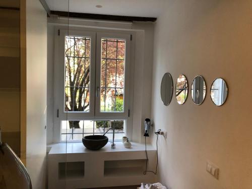 een badkamer met een raam met een wastafel en spiegels bij Un Piccolo Rifugio in Ferrara