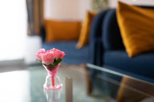 a pink vase filled with pink flowers on top of a table at Hotel Königshof The Arthouse in Cologne