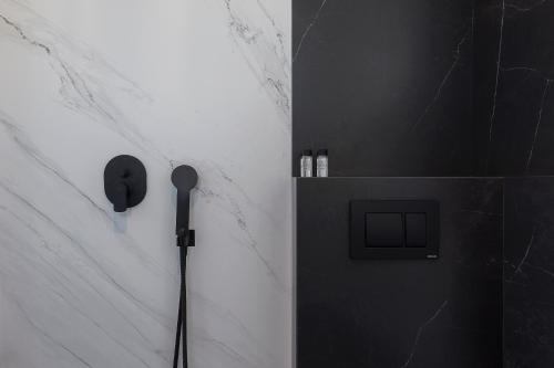 a shower with a black and white wall at Athenian Lofts in Athens
