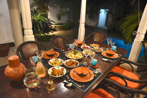 a wooden table with plates of food on it at Orchard House Galle in Galle