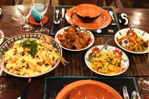 a wooden table with plates of food on it at Orchard House Galle in Galle