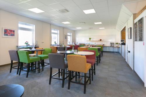 a restaurant with tables and chairs in a cafeteria at Kalmar Hotell in Kalmar