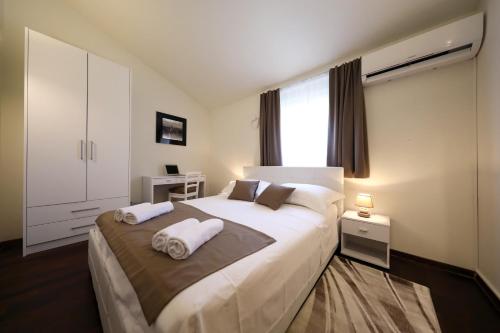 a bedroom with a large white bed with two pillows at Bellevue Hill apartment in Zadar