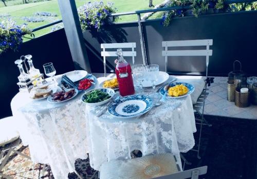a white table with plates of food on it at La Zarabba Boutique Hotel in Ponti Sul Mincio