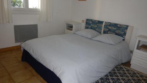 a bedroom with a white bed and a window at Les mimosas in Collioure