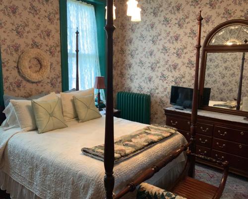 a bedroom with a bed and a dresser and a mirror at Susquehanna Manor Inn in Marietta