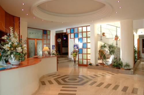 un vestíbulo con flores y plantas en un edificio en Hotel La Sorgente HS, en Paestum