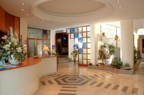 a lobby with flowers and plants in a building at Hotel La Sorgente HS in Paestum