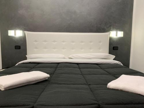 ローマにあるItaly Guest Houseのベッドルーム1室(大型ベッド1台、白い枕2つ付)