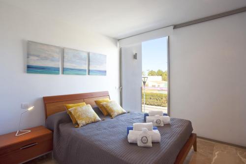 a bedroom with a bed with towels on it at Villa Salines House in Alcudia