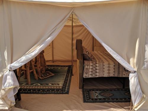a tent with a bed and rugs in a room at FunStays Glamping Setup Tent in RV Park #6 OK-T6 in Moab