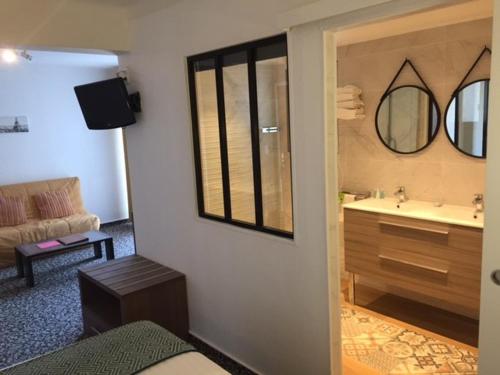 a room with a bathroom with a sink and a mirror at Le Galion Hotel et Restaurant Canet Plage - Logis in Canet-en-Roussillon