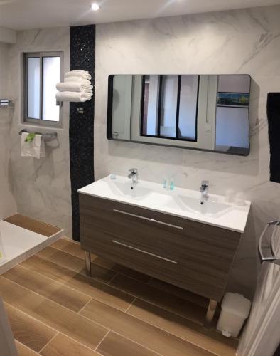 a bathroom with a sink and a mirror at Le Galion Hotel et Restaurant Canet Plage - Logis in Canet-en-Roussillon