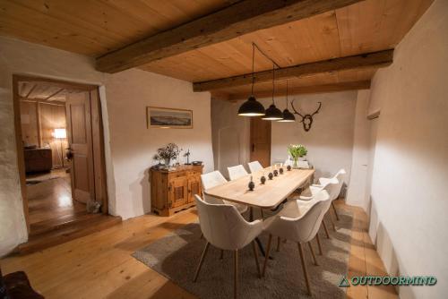 a dining room with a table and white chairs at Tgesa Ferrera in Schmitten