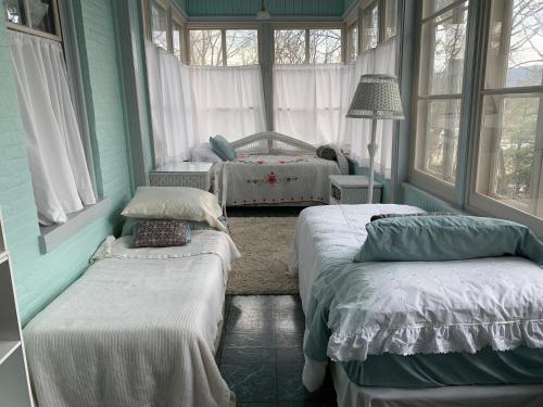 a bedroom with two beds in a room with windows at Susquehanna Manor Inn in Marietta
