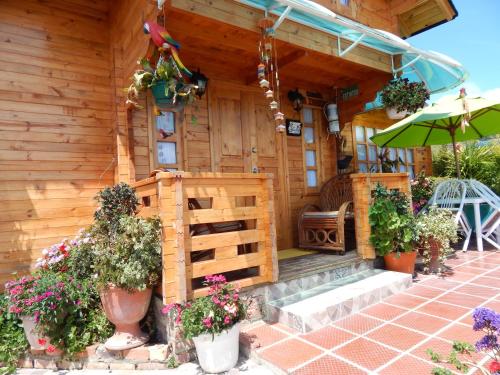 a wooden house with flowers in front of it at Villa Evelia in Aquitania