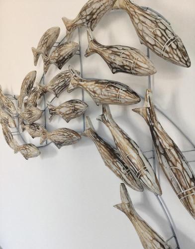 a group of birds sculpture on a wall at Gigi Rooms in Poros
