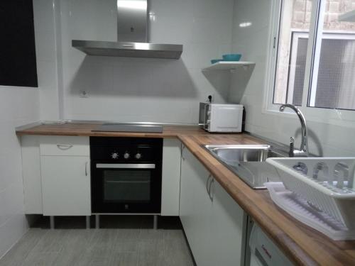a small kitchen with a sink and a stove at Sofia's Flat in Valencia