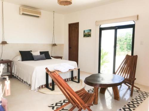 1 dormitorio con cama, mesa y ventana en Kuka y Naranjo, en Mérida
