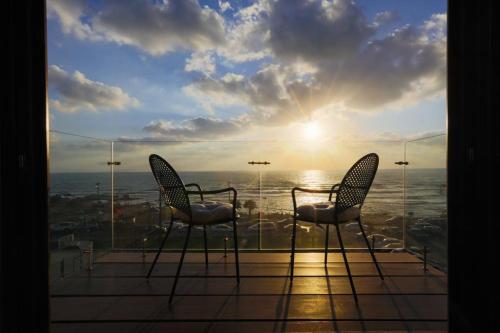 two chairs on a balcony with a view of the ocean at El Boutique Hotel in Soûr