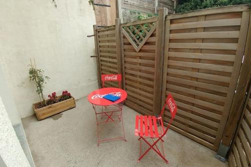 d'une terrasse avec 2 chaises et une table et des chaises rouges. dans l'établissement Maisonette en HYPERCENTRE calme avec terrasse, à Cholet