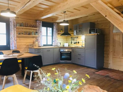 a kitchen in a wooden cabin with a table and chairs at Roubenky Bublava in Bublava
