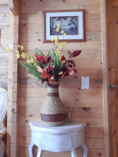 a vase with flowers on a table in a room at Villa Evelia in Aquitania
