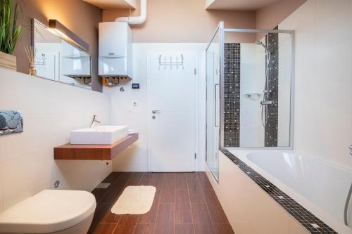 a bathroom with a tub and a toilet and a sink at Onyx - Luxury Sunny Apartment in Pula