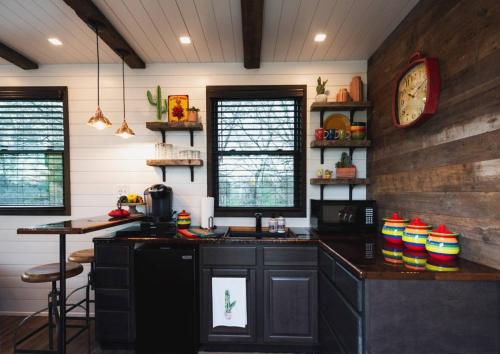 una cucina con un lavandino e un orologio a parete di The Hacienda Beautiful New Container Home 12 min to Magnolia a Waco
