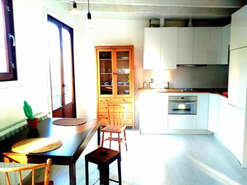 une cuisine avec une table et des chaises et une cuisine avec des placards blancs dans l'établissement Apartamento Sayly, à Burgos
