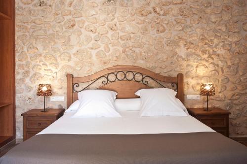 a bedroom with a bed with two lamps on tables at Agroturismo Es Quatre Cantons in Binissalem