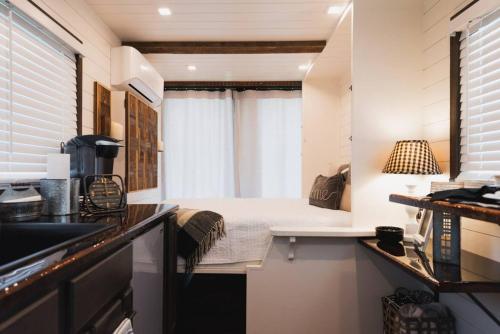 a small kitchen with a bed in a tiny house at Tiny CargoHome near Magnolia Silos Baylor in Waco