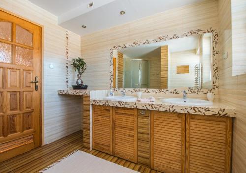 une salle de bain avec deux lavabos et un grand miroir dans l'établissement Pokoje "u Walusia", à Bustryk