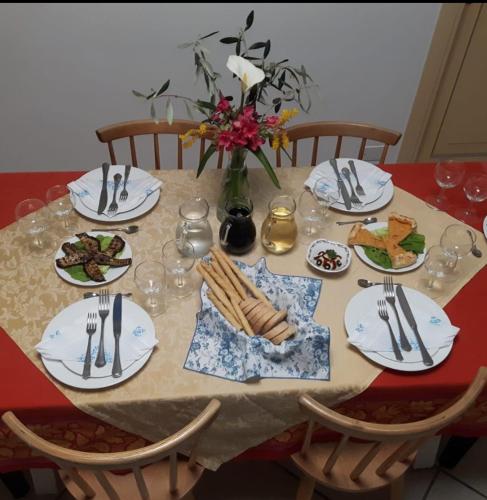 a table with plates of food and a vase of flowers at Agriturismo I Pipetta in Levanto